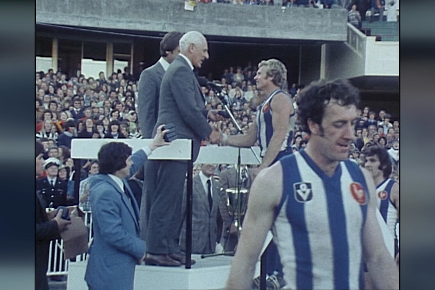 Barry Cable shakes an official's hand as he receives his premiership medal