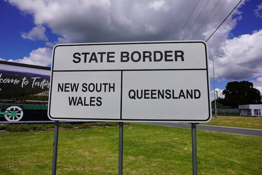A road sign that reads "state border", indicating New South Wales and Queensland on either side.