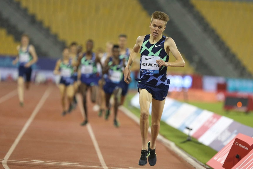 An athlete crosses the line, with the chasing pack well in the background.