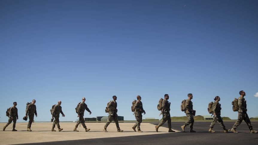 The marines walk across the tarmac