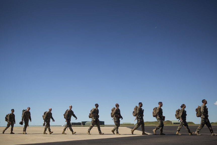 The marines walk across the tarmac