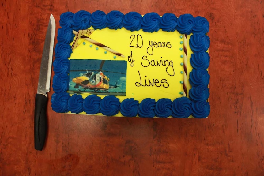 Blue and yellow cake with a photograph of a helicopter on it