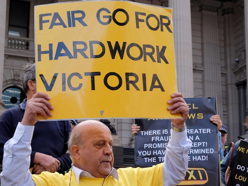 Taxi driver holding up a sign at Vic Parliament protest