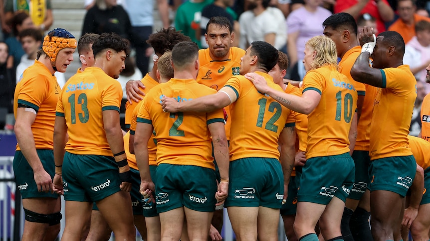 Wallabies players stand in a huddle