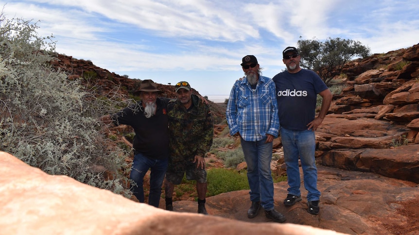 Four men standing at Lake Torrens