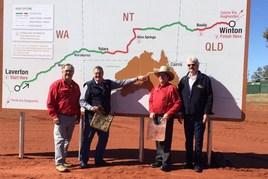 Patrick hill, Damien Ryan, Rick Britton and Butch Lenton point at map of the Outback Way.
