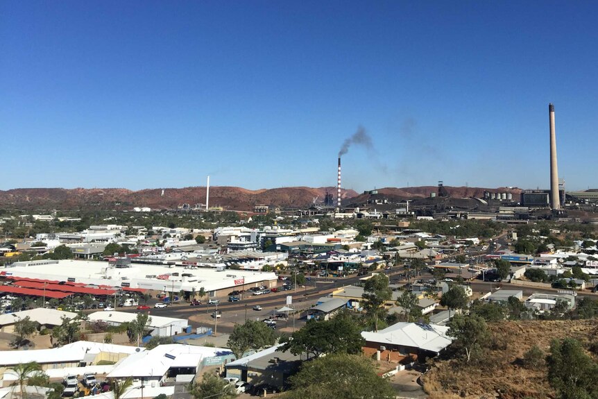 a blue sky with a view of outback town from a hill