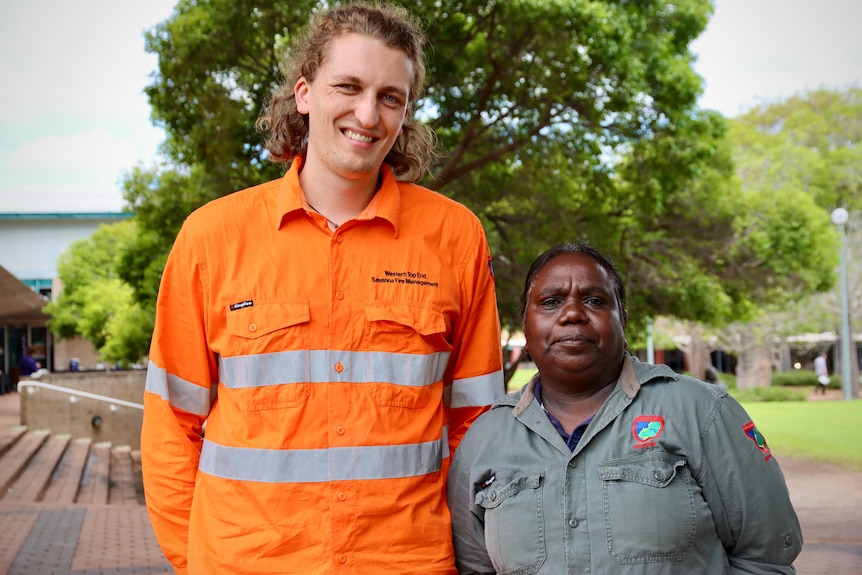 A tall man stands next to a short woman. They both wear ranger uniforms