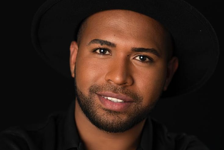 A close up of a man with arms crossed looking at the camera. 