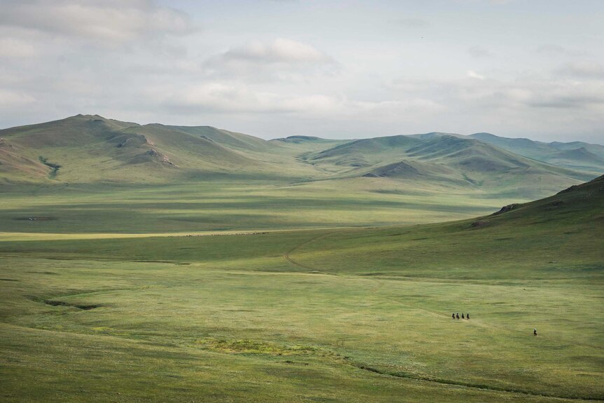 Riders dwarfed by the Mongolian landscape during the Mongol Derby.
