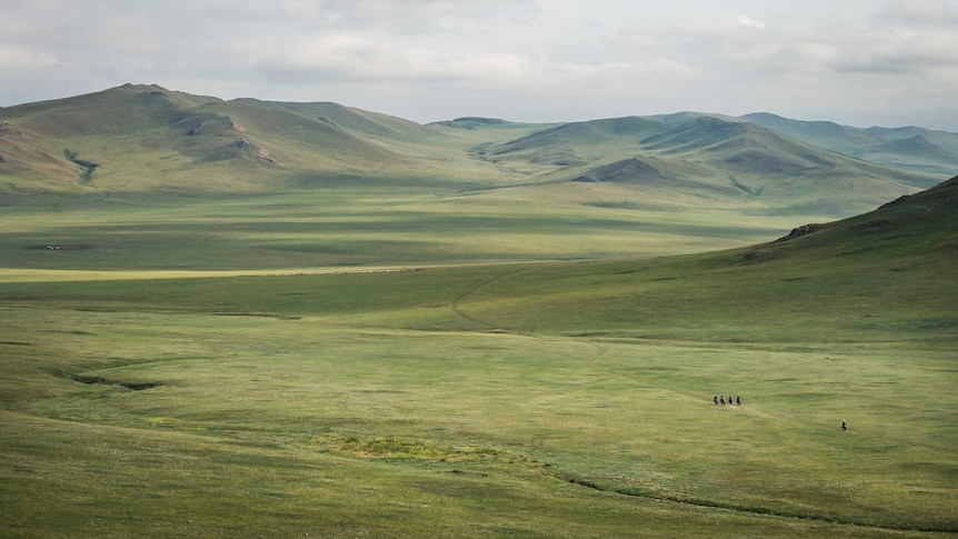 Riders dwarfed by the Mongolian landscape during the Mongol Derby.