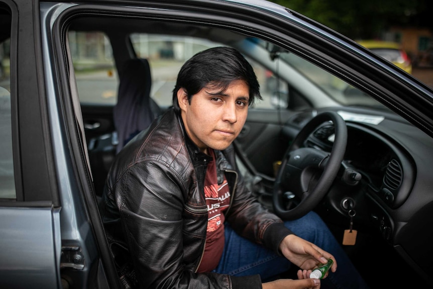 Man sits in drivers seat with door open