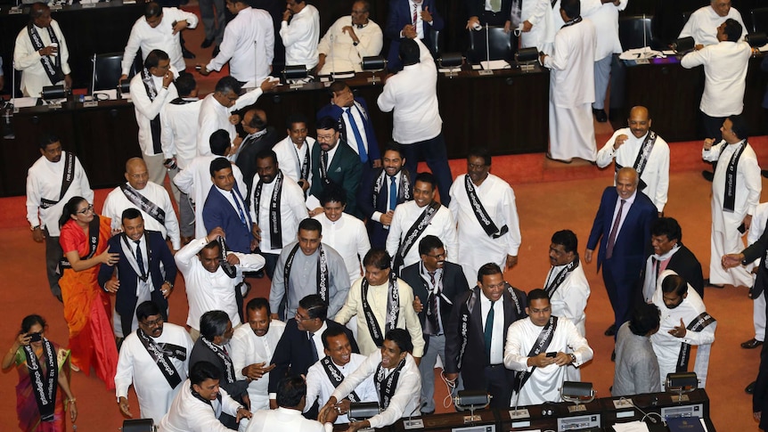 Sri Lanka's United National Party members celebrate a successful vote of no confidence in Prime Minister Mahinda Rajapaksa