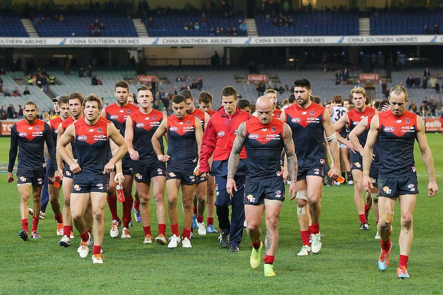 Melbourne players walk off the MCG after losing to GWS in round 21, 2014.