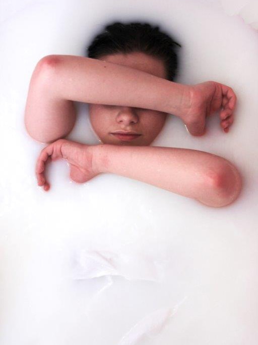 A young woman in a bathtub of milk