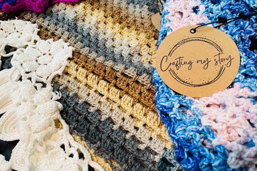 A handmade blanket with a tag that reads "Crafting My Story".