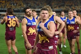 Brisbane's Dayne Zorko stares across the ground looking sad as his teammates react to a bad loss against Melbourne.
