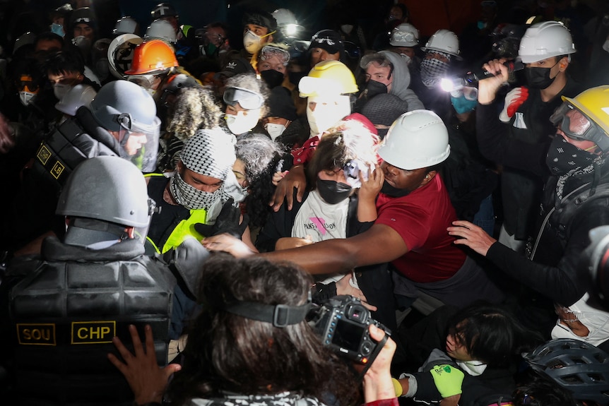 Die Polizei rauft in einer engen Gruppe mit Demonstranten