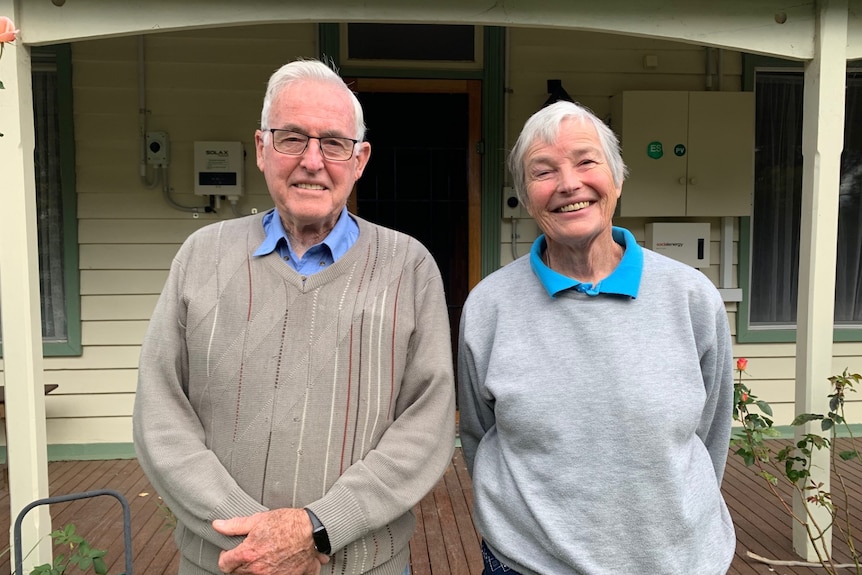 Senior couple standing outsde their home