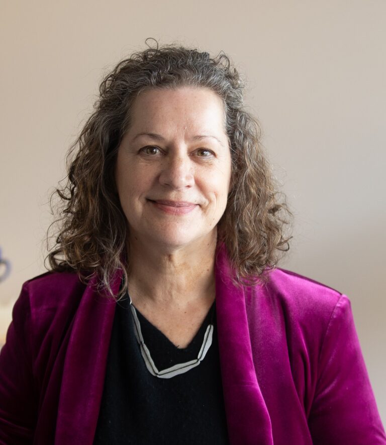 A woman smiles at the camera