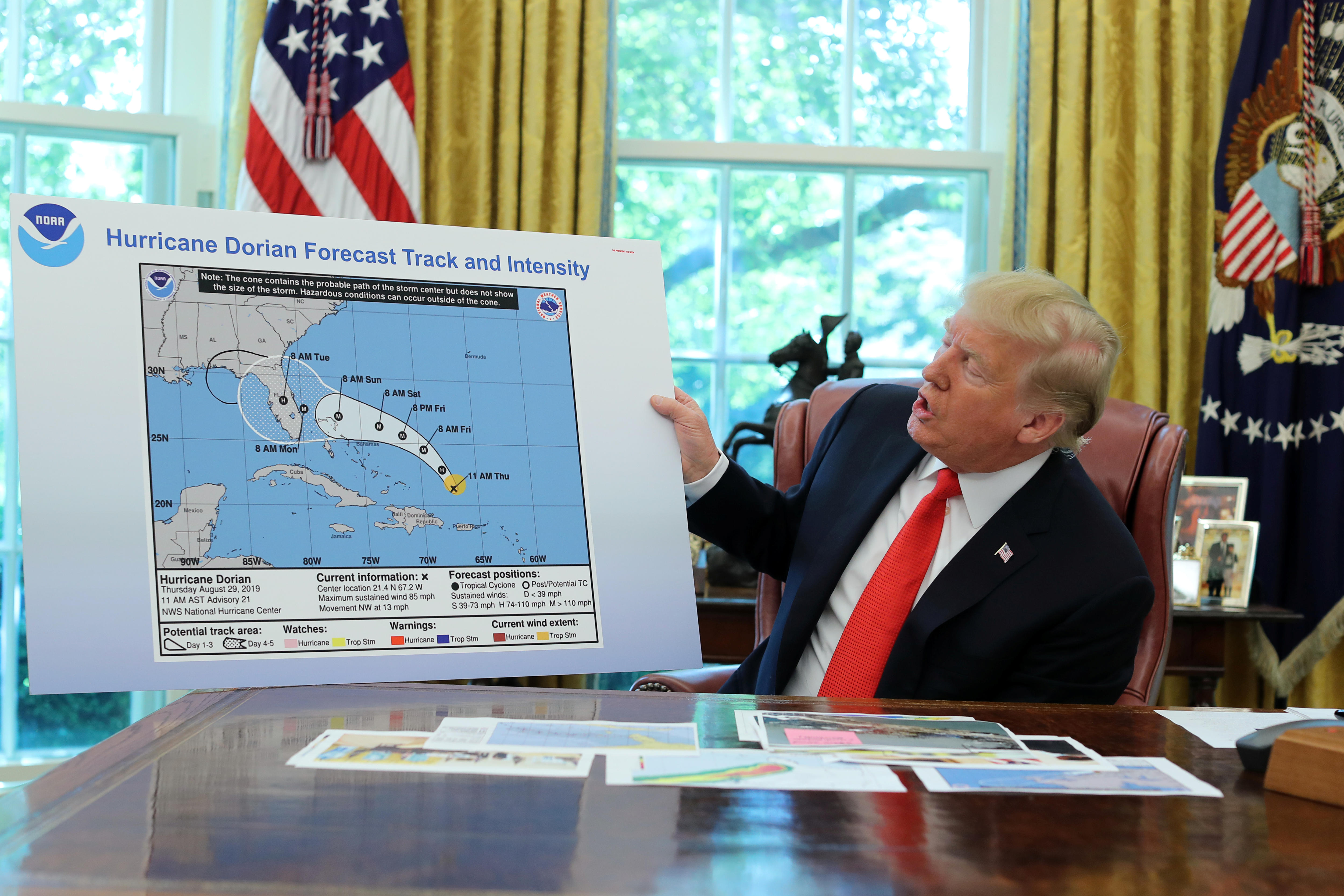 Trump with a hurricane map at his desk at the White House