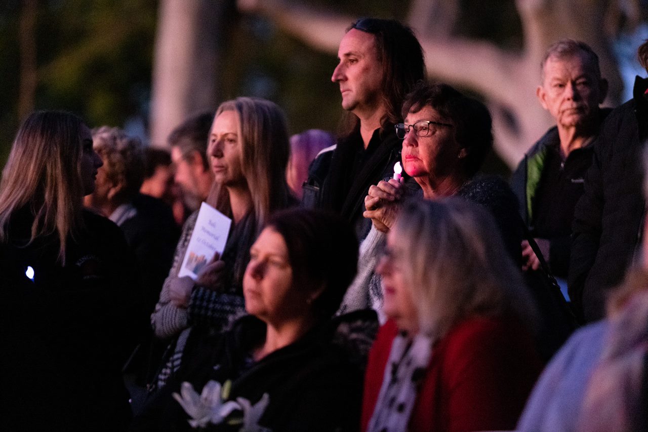 Crowds looking somber at sunrise with lit candles