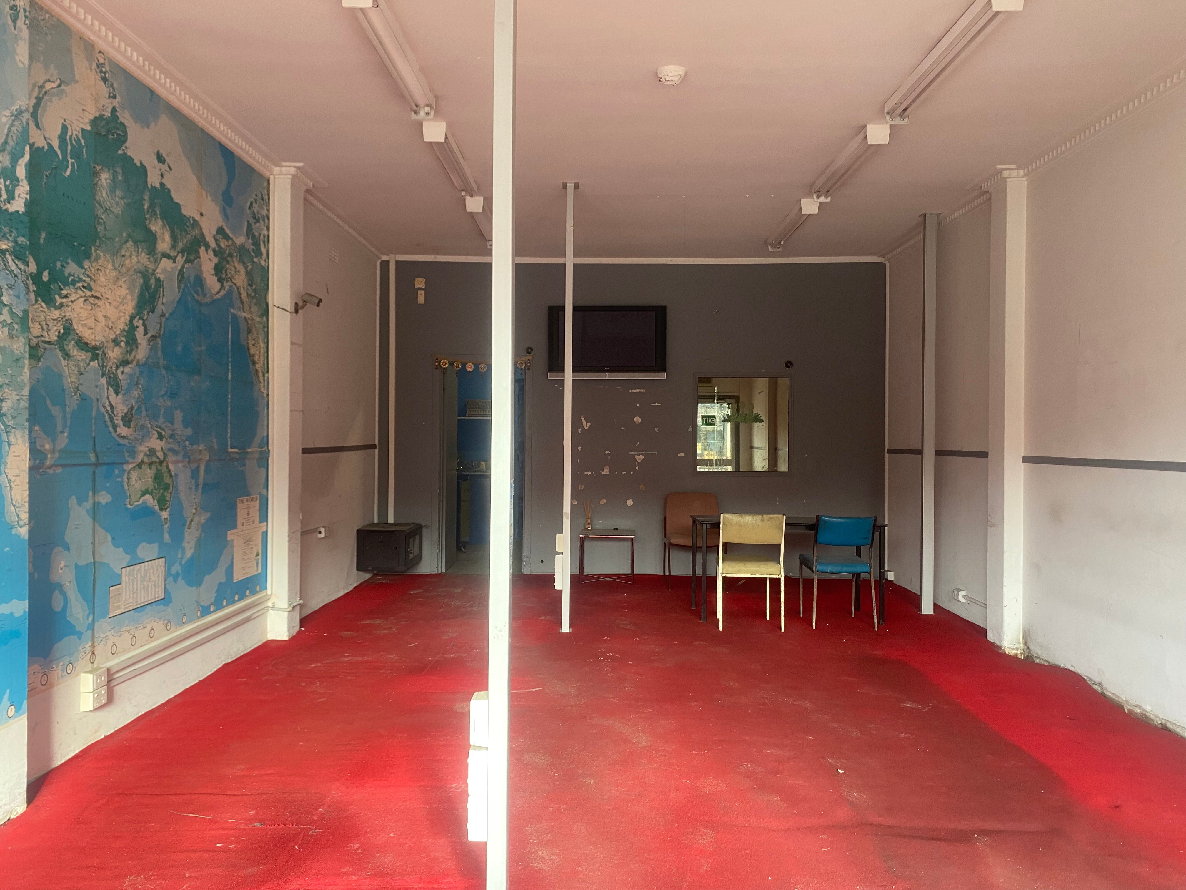 An empty showcase with a map on the wall.