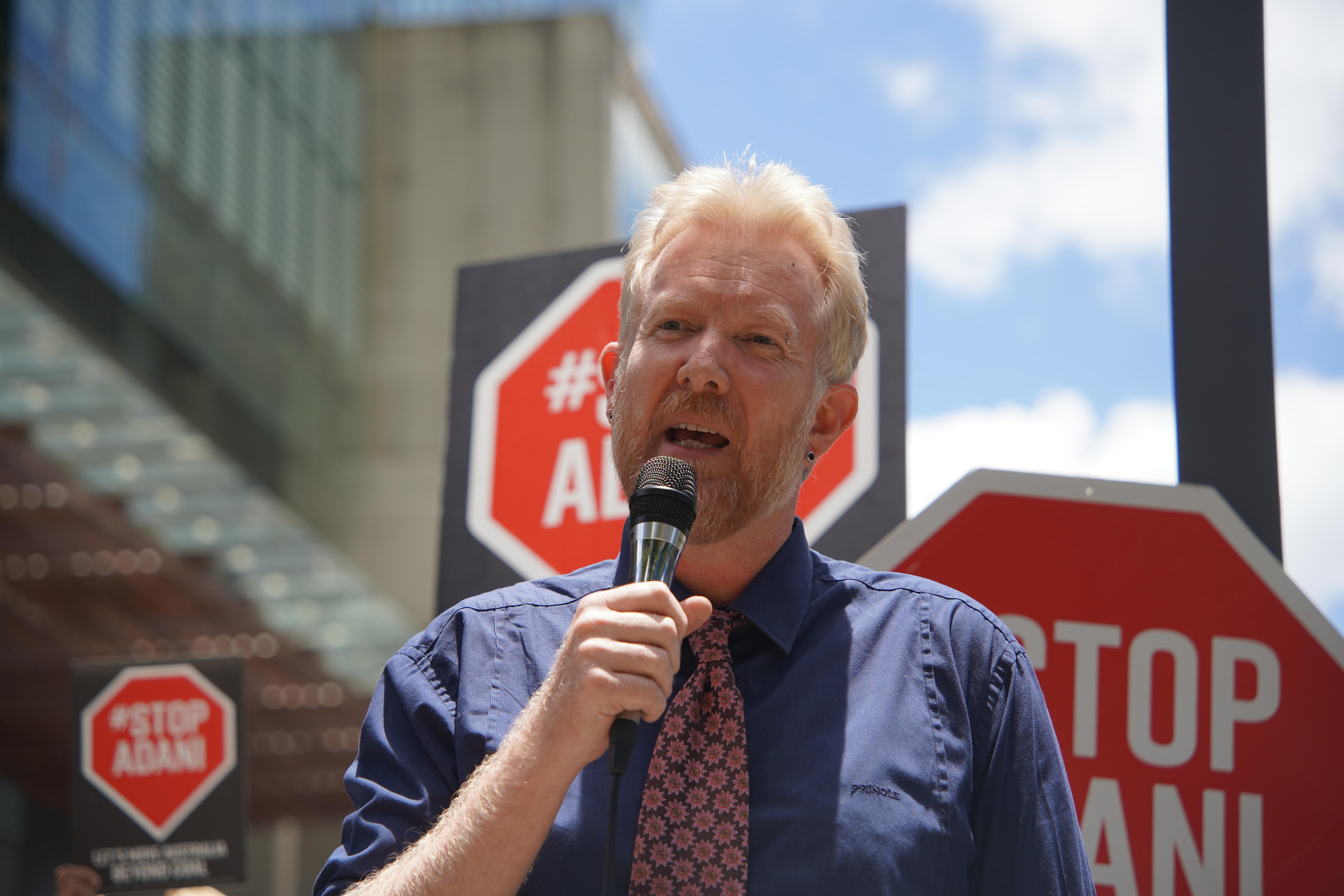 Ben Pennings speaking into a microphone outside the court house.