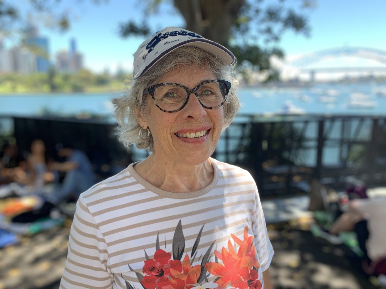  Melbourne resident, Diane Mead pictured smiling, wearing black rim glasses and a grey and white shirt and viser.