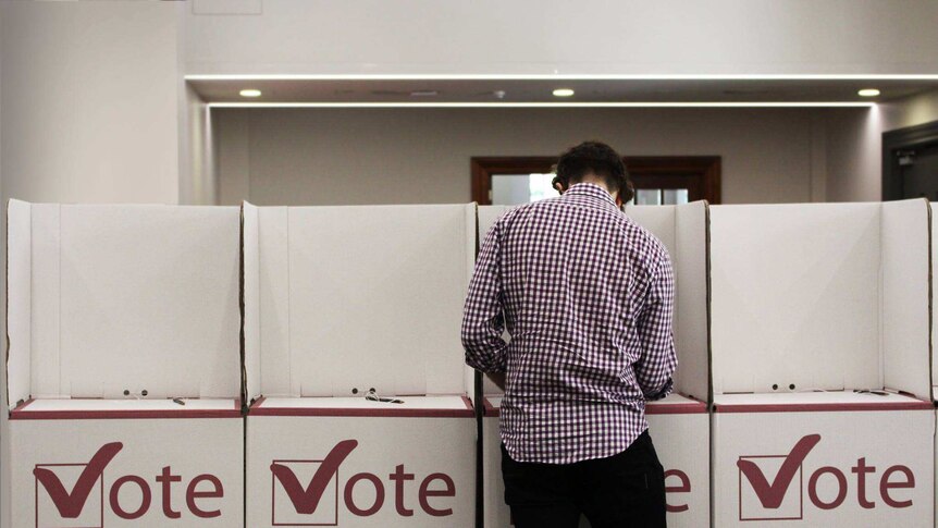 A man fills in his vote at the polling booth