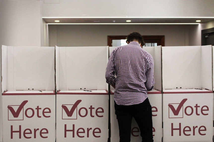 A man fills in his vote at the polling booth.