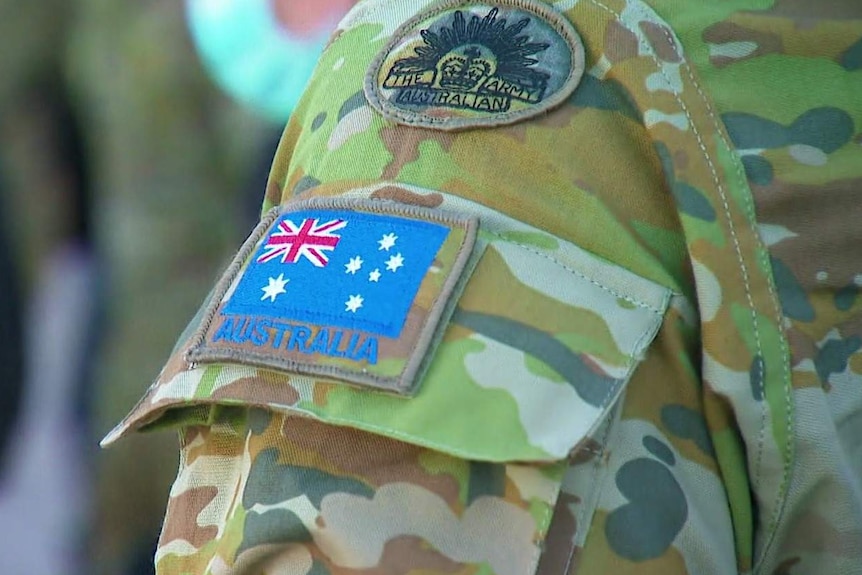 A close-up of an Australian Army patch and an Australian flag patch on an ADF officer's uniform.
