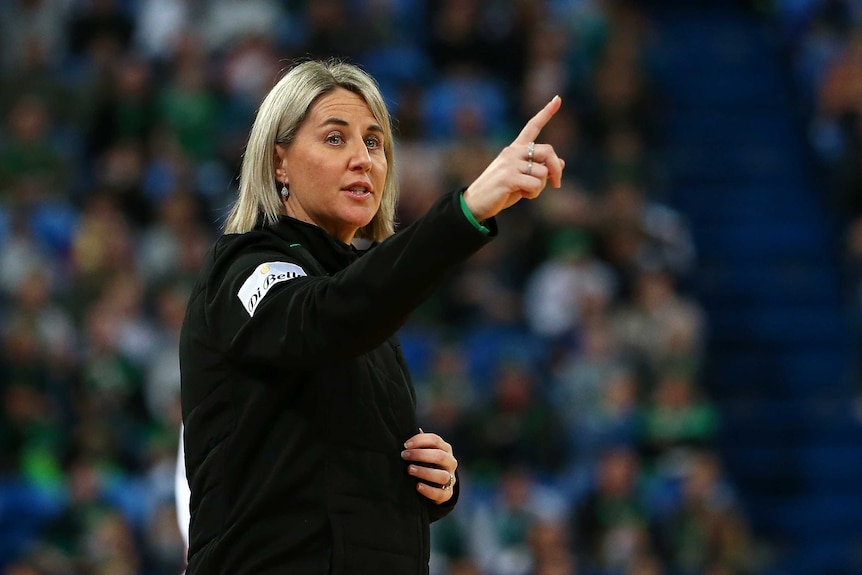 A Super Netball team coach points her finger at players as she gives instructions during a game.