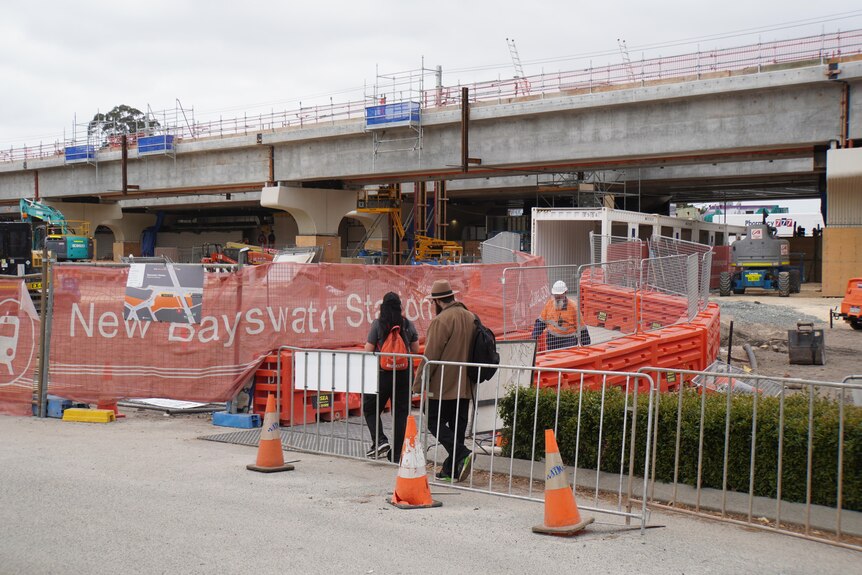 Pedestrians take a detour around construction works for the new Bayswater station