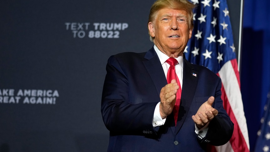 Former president Donald Trump claps his hand together at rally in Manchester, New Hampshire.