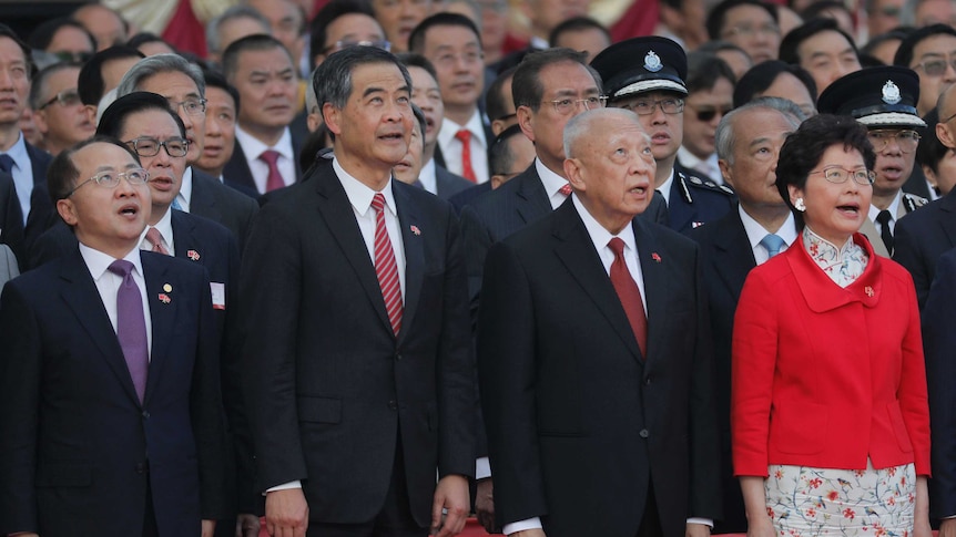 Group of political leaders in suits sing and look up out of frame
