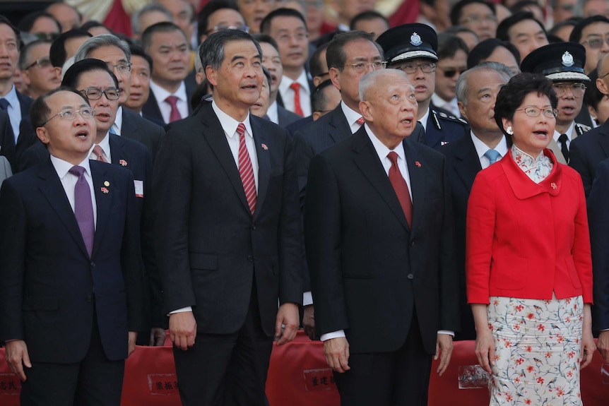 Group of political leaders in suits sing and look up out of frame