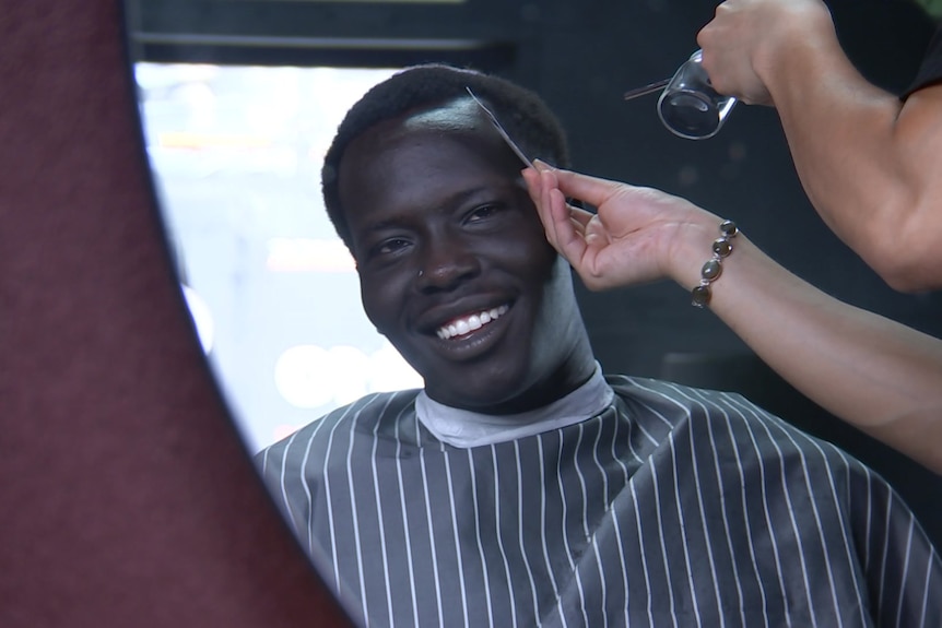 A young man getting his hair done.