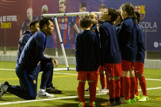 Coaches kneel to talk to young players