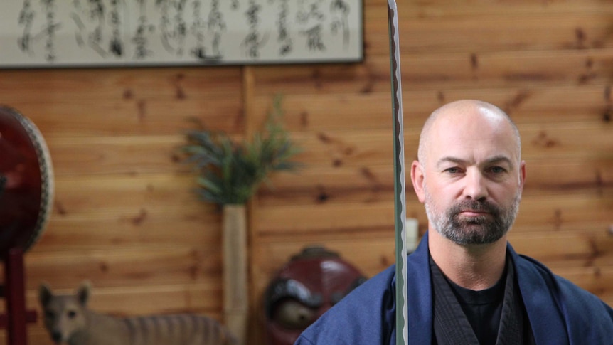 Duncan Stewart, owner of Bujinkan Tasmania Budo Dojo, holds a samurai sword in his dojo in Hobart, Tasmania