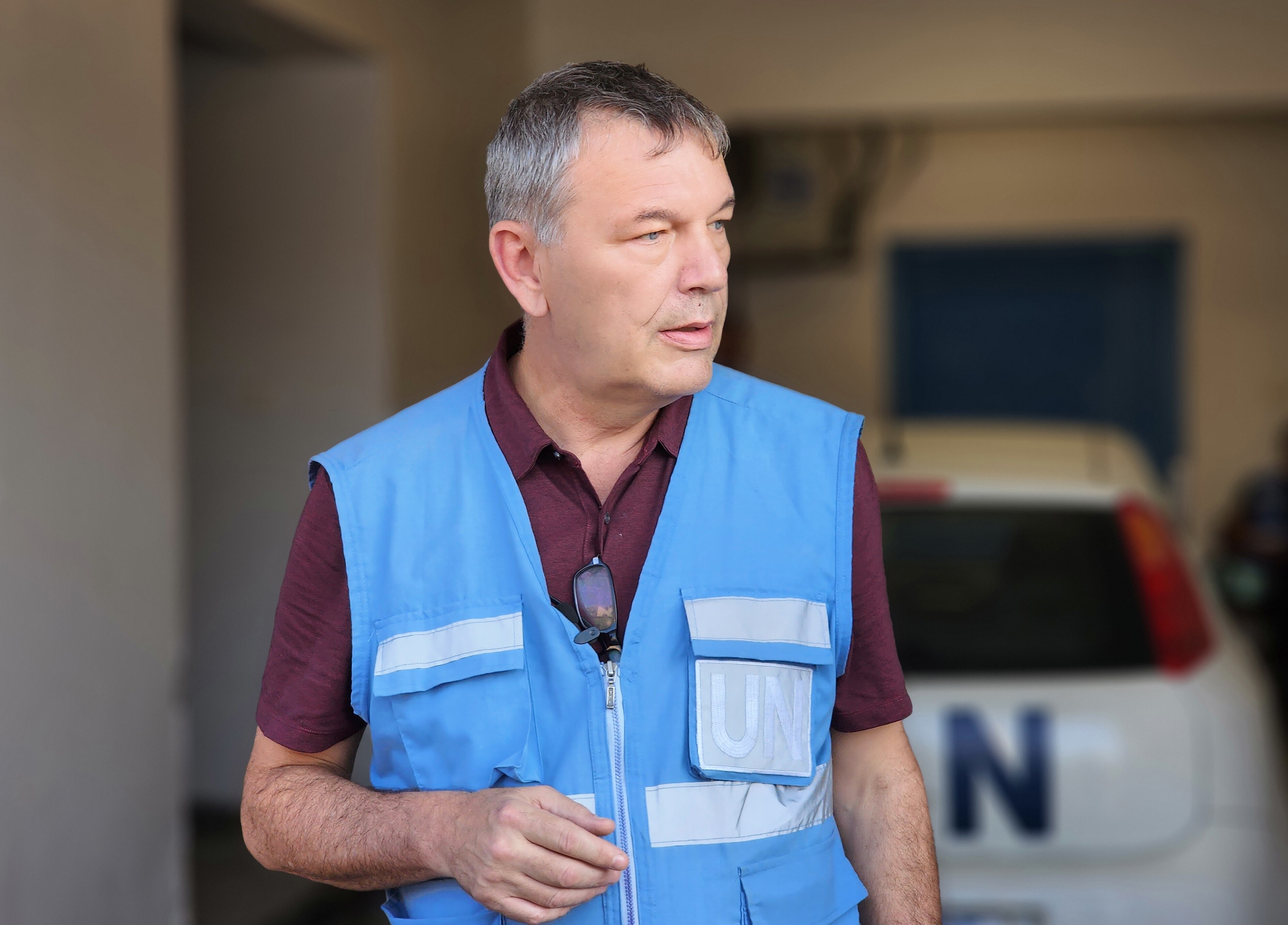 A man wearing a blue vest that says UN on it.