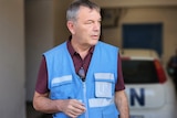 A man wearing a blue vest that says UN on it.