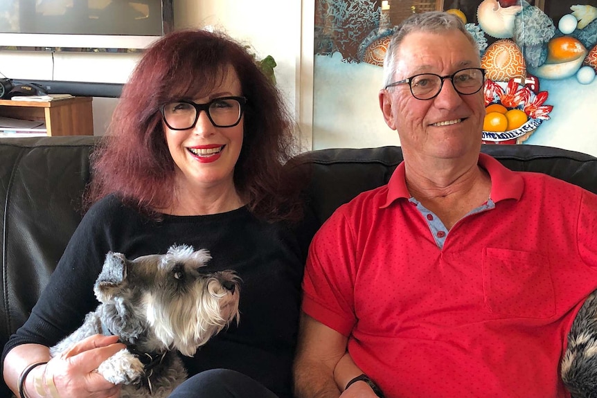 Katy and John Woodroffe photographed sitting on a couch.