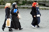 Turkish women wearing headscarves walk through Istanbul.