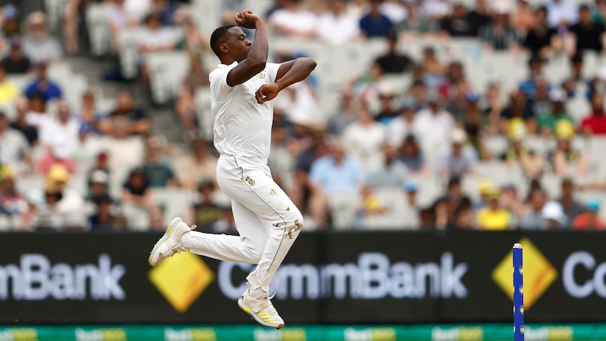 A South African bowler runs in and leaps in the air as he is about to bowl a delivery during a Test match.