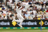 A South African bowler runs in and leaps in the air as he is about to bowl a delivery during a Test match.