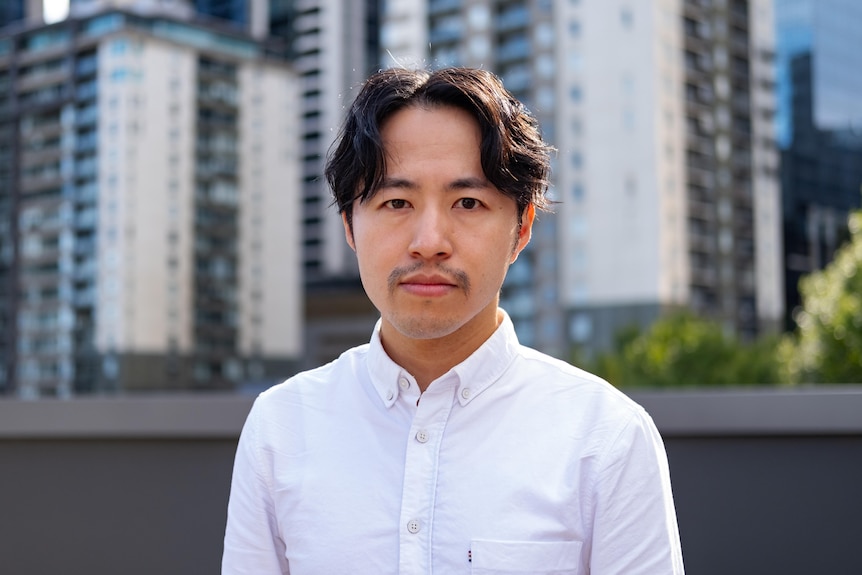 A man standing in the front of some apartment building