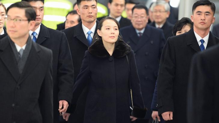 Kim Yo Jong walking through an airport surrounded by bodyguards