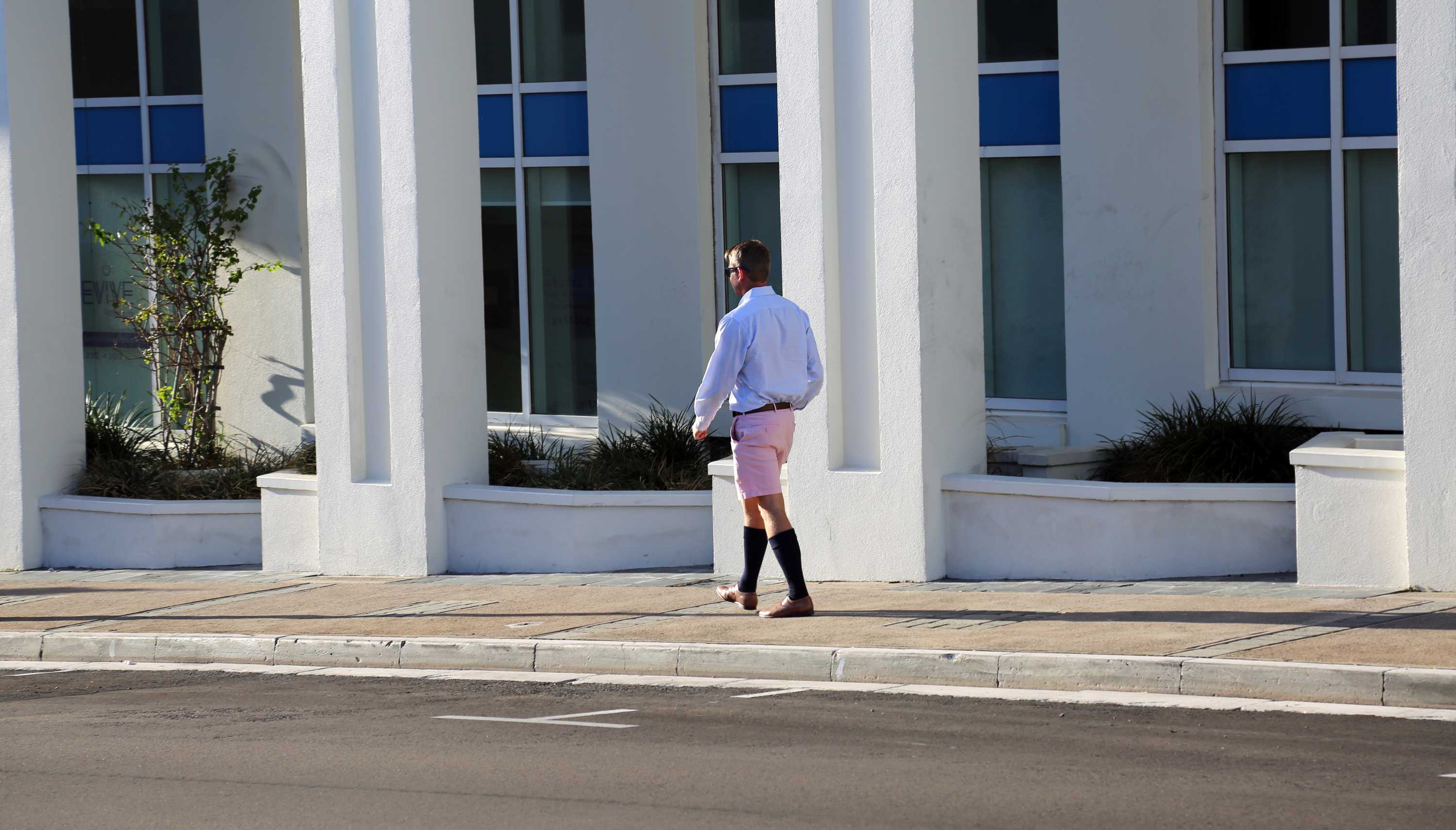 A man walks the streets of Bermuda dressed in what are known as Berumda shorts.