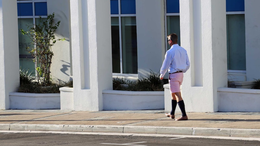 A man walks the streets of Bermuda dressed in what are known as Berumda shorts.
